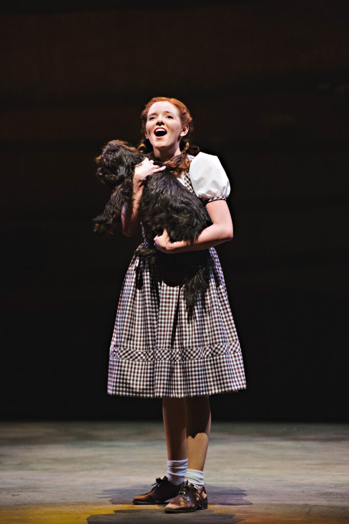 AJ Bridel as Dorothy with Flynn as Toto in The Wizard of Oz, 2015